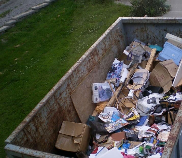 Roll-off dumpster loaded with household debris, ready for pickup